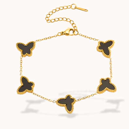 Gold bracelet with black butterfly charms on a white background
