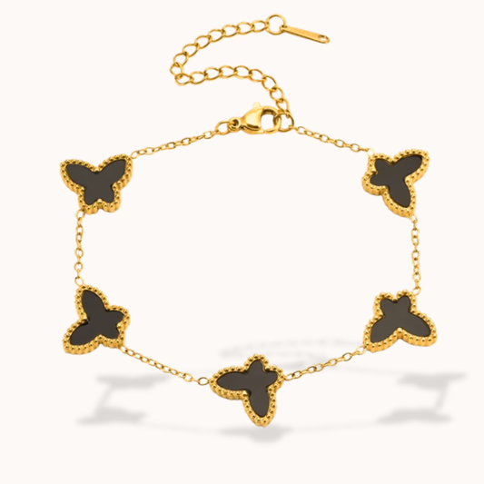 Gold bracelet with black butterfly charms on a white background