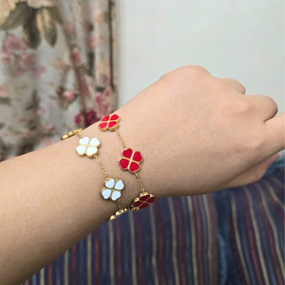Bracelet with colorful flower-shaped charms on a wrist against a floral background
