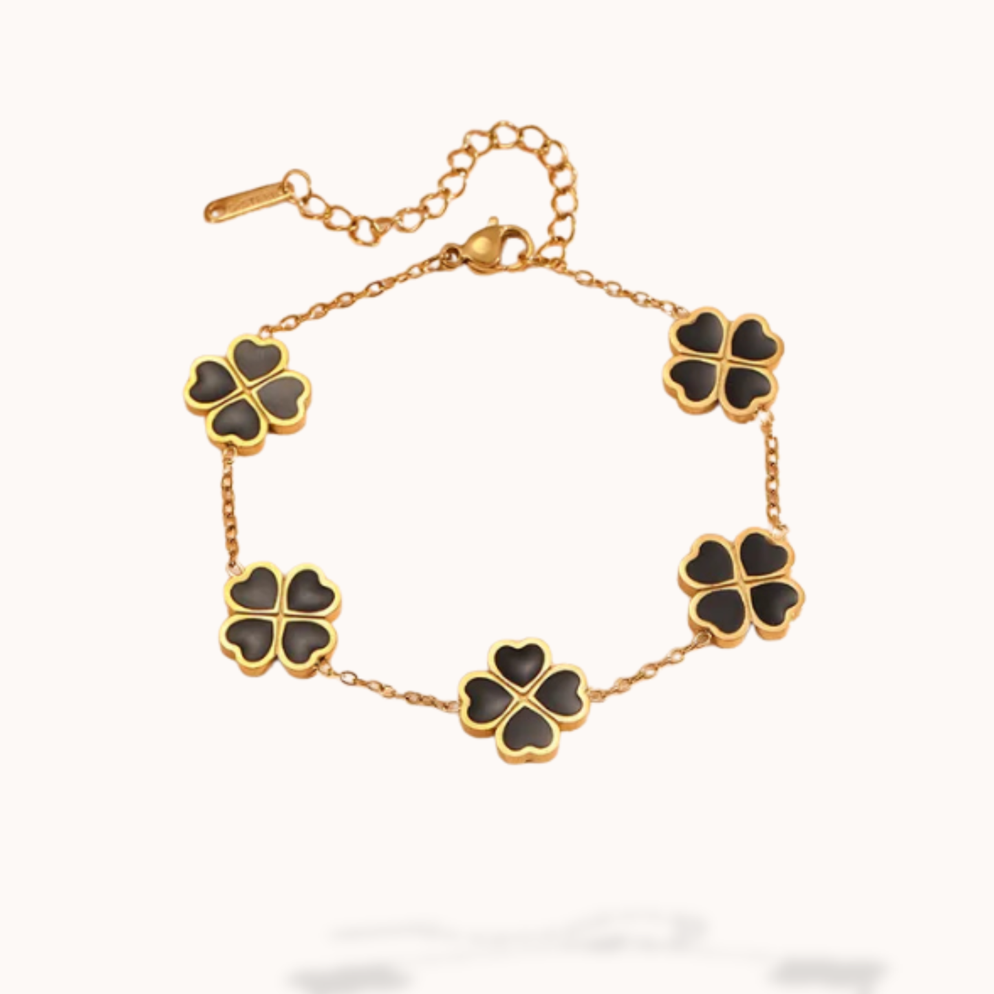 Gold bracelet with black clover-shaped charms on a white background