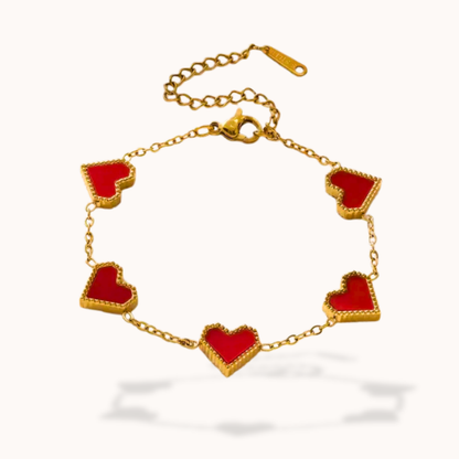 Gold bracelet with red heart-shaped charms on a white background