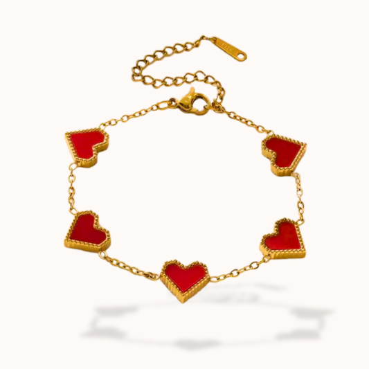 Gold bracelet with red heart-shaped charms on a white background
