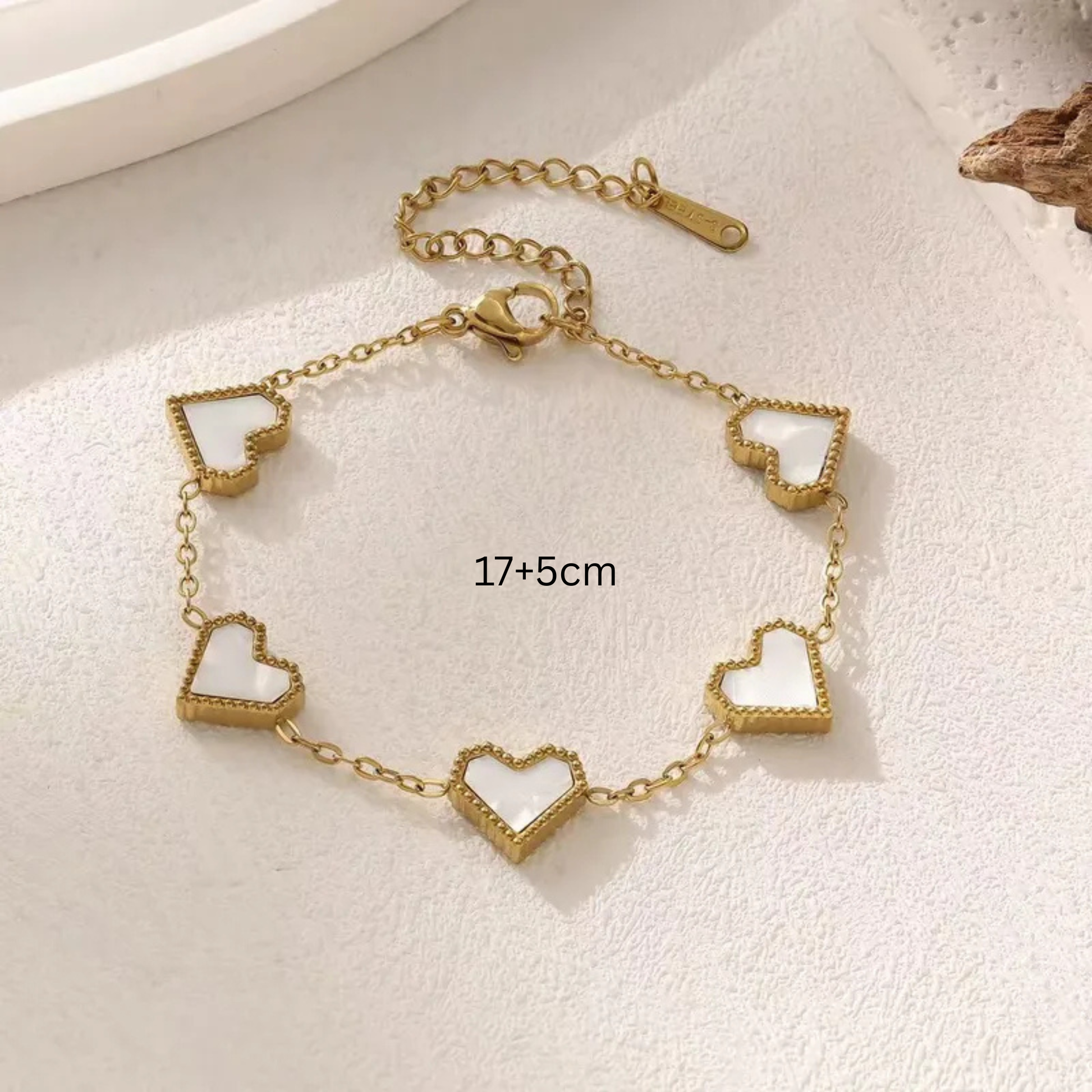 Gold bracelet with heart-shaped links on a light background