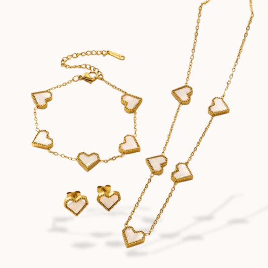Gold jewelry set with heart-shaped pendants on a white background
