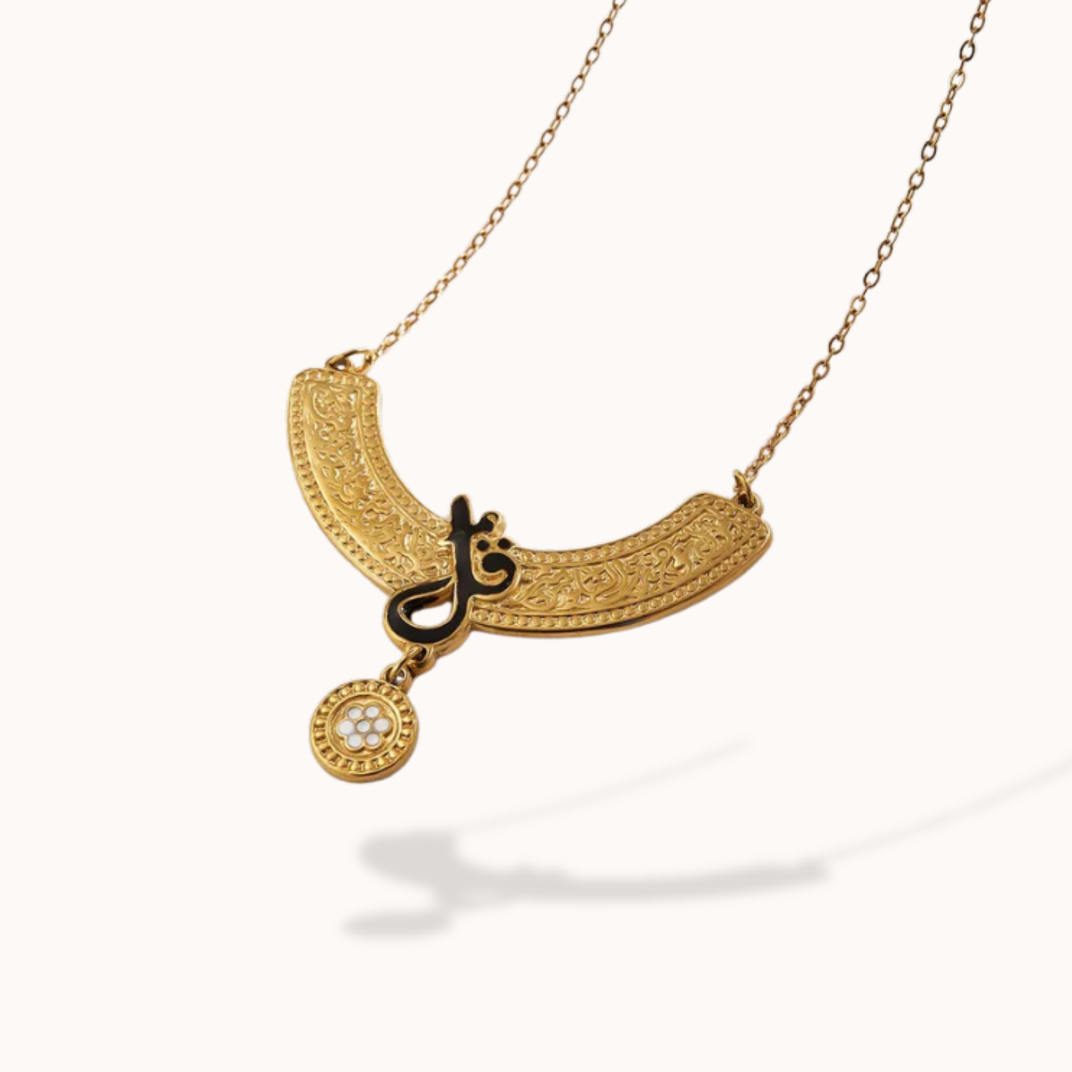 Gold necklace with arabic intricate design on a white background