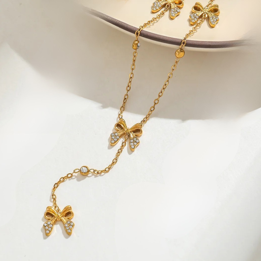 Gold necklace with bow-shaped pendants on a white background