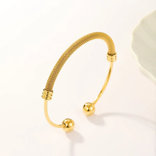 Gold bracelet with spherical ends on a light background