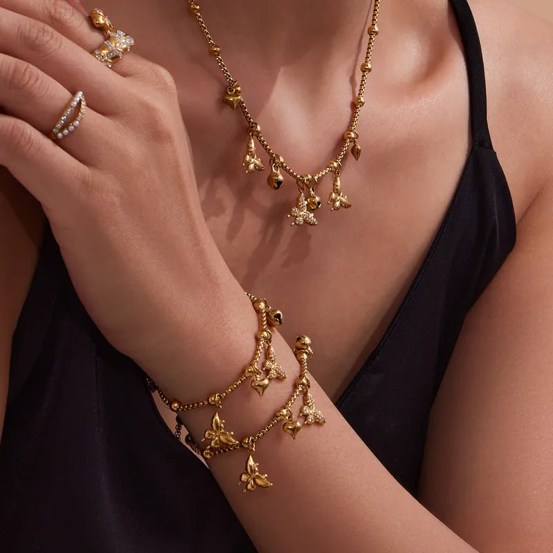 Gold jewelry including a necklace, bracelet, and rings on a person wearing a black top.