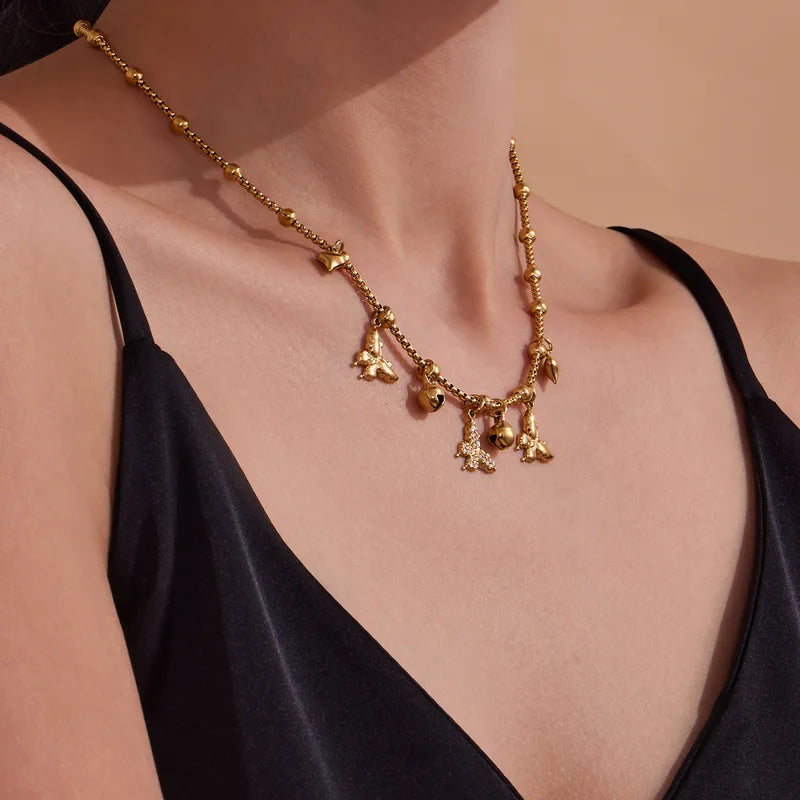 Gold necklace with butterfly-shaped pendants on a model wearing a black top.