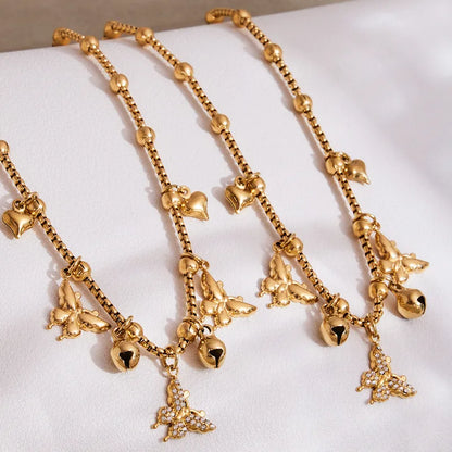 Two gold necklaces with charms on a white surface