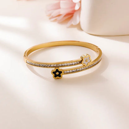 Gold bracelet with floral designs on a light background