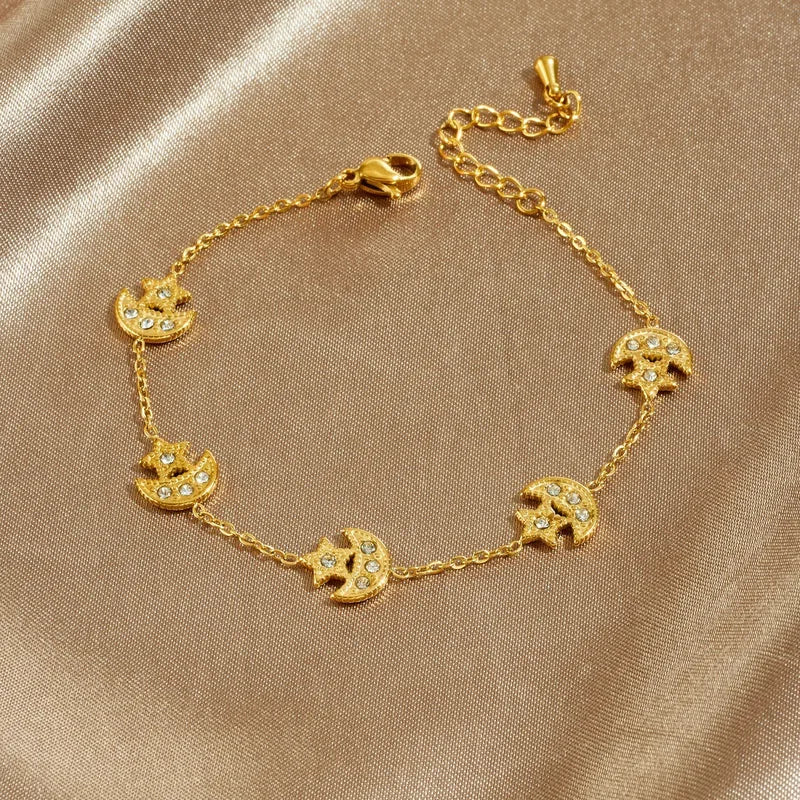 Gold bracelet with elephant designs on a beige fabric background