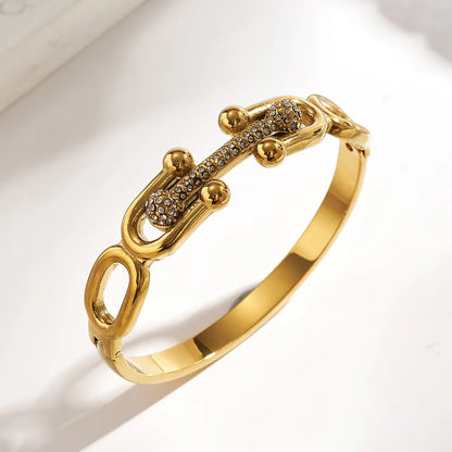 Gold bracelet with intricate design on a light background