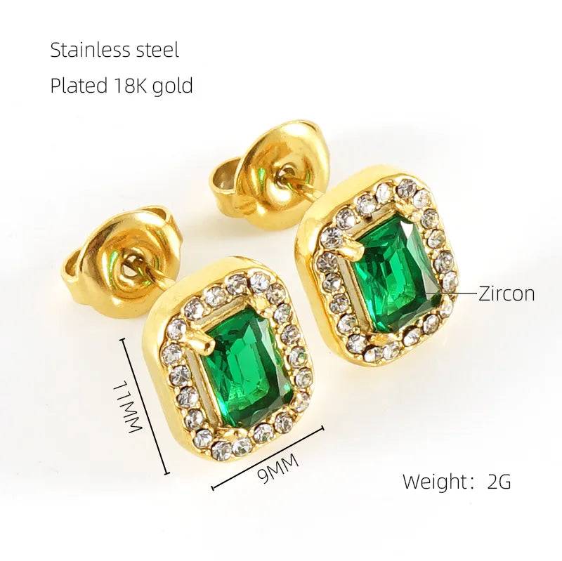 Gold earrings with green gemstones and zircon details on a white background