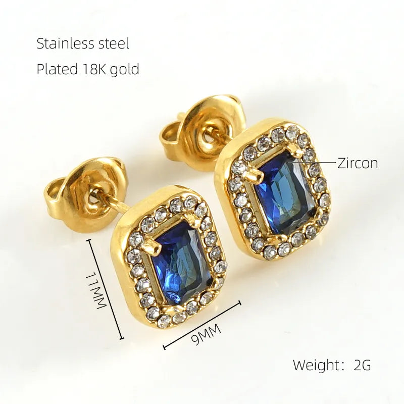 Gold earrings with blue gemstones and zircon on a white background