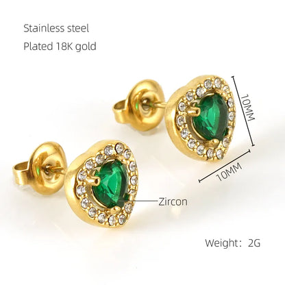 Gold earrings with green gemstones and zircon details on a white background