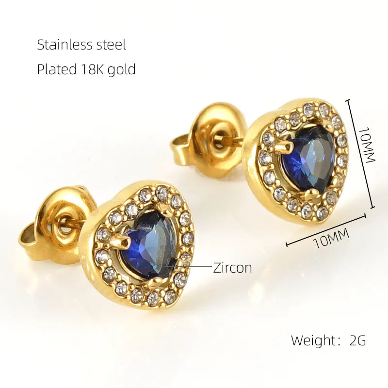 Gold earrings with blue gemstones and zircon on a white background