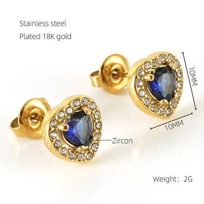 Gold earrings with blue gemstones and zircon on a white background