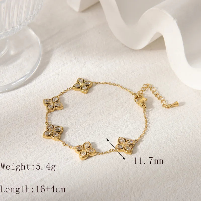 Gold bracelet with floral designs on a white fabric background