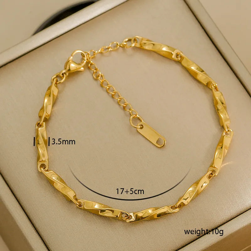 Gold bracelet with measurements on a beige background