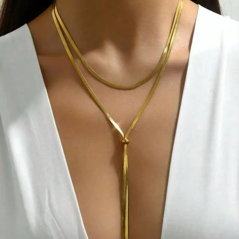 Gold necklace on a mannequin with a white top