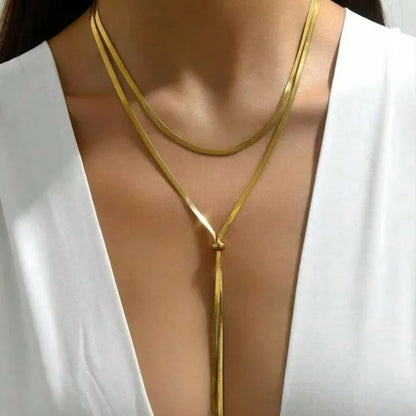 Gold necklace on a mannequin with a white top