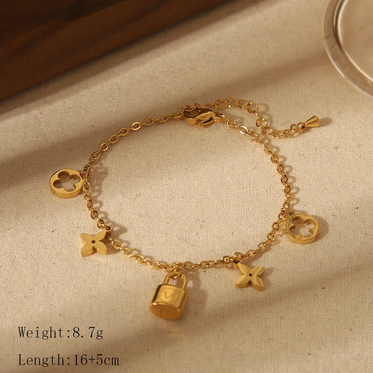 Gold bracelet with charms on a beige fabric background