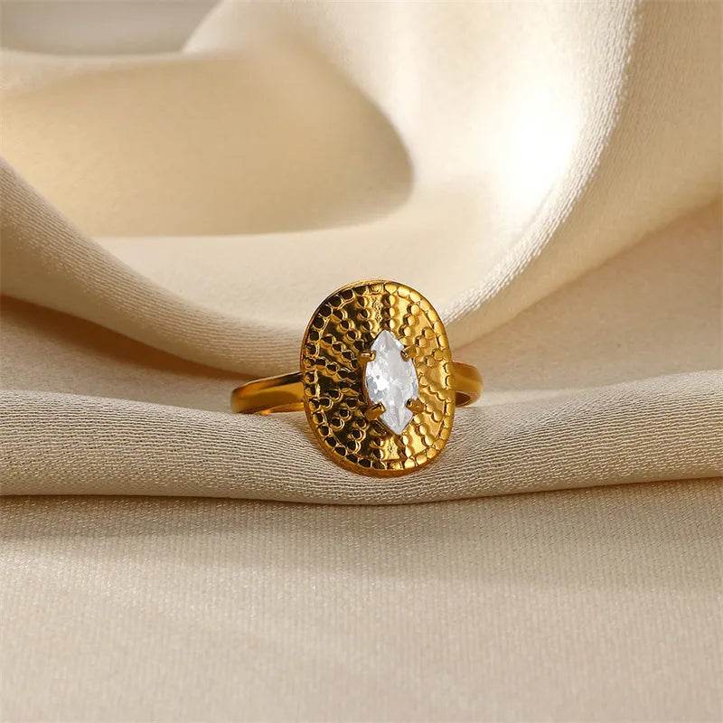 Gold ring with a diamond on beige fabric