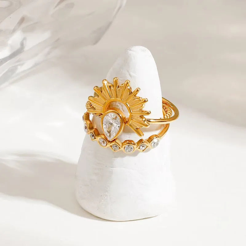 Gold ring with a central gemstone on a white stone surface