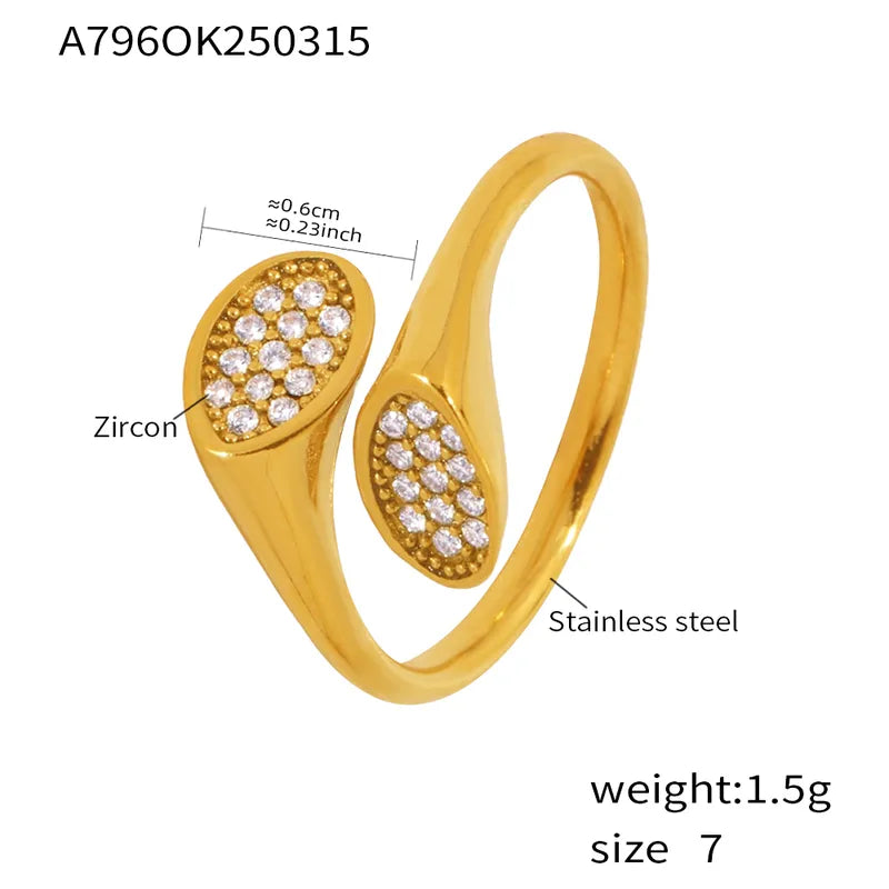 Gold ring with zircon stones and measurements on a white background