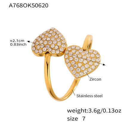 Gold heart-shaped ring with diamond accents on a white background with measurment