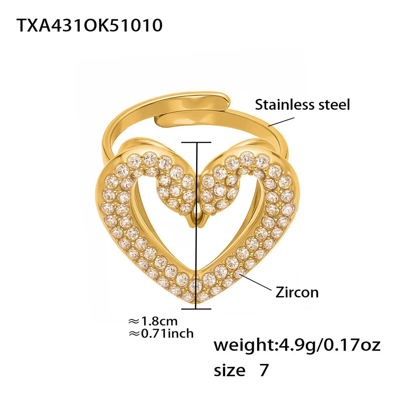 Gold heart-shaped ring with zircon stones and technical details on a white background