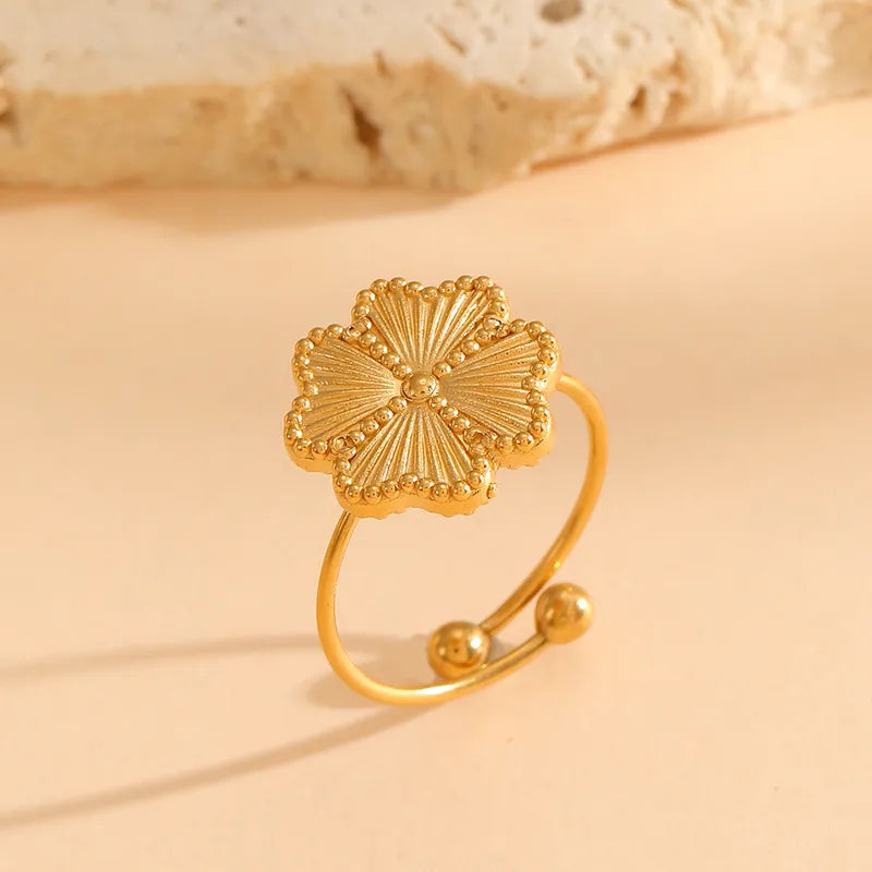 Gold bracelet with floral design on a beige background
