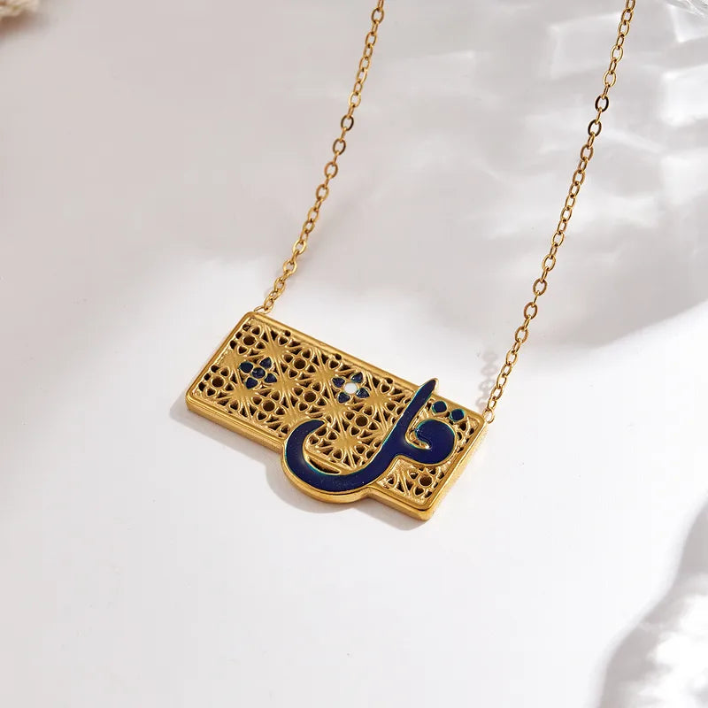 Gold necklace with a rectangular pendant featuring Arabic calligraphy in black on a white background