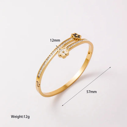 Gold bracelet with measurements on a white background