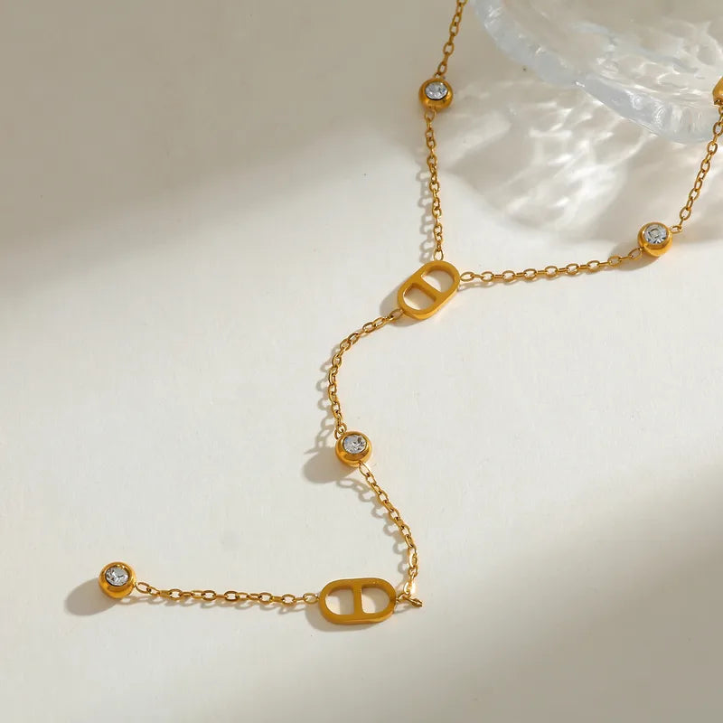 Gold necklace with diamond-like stones on a light background
