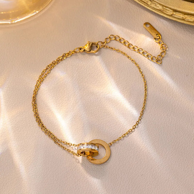 Gold bracelet with a diamond clasp on a beige surface