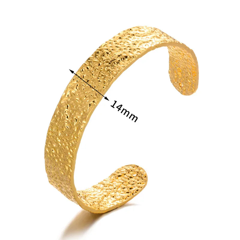 Gold bracelet with textured surface and measurement label on a white background
