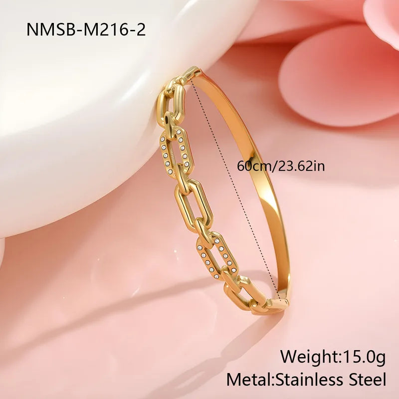 Gold chain bracelet with measurements and material details on a soft pink background