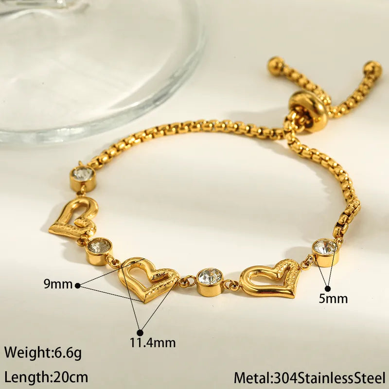 Gold bracelet with heart-shaped charms on a white background