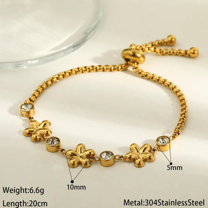 Gold bracelet with floral designs and crystals on a white background