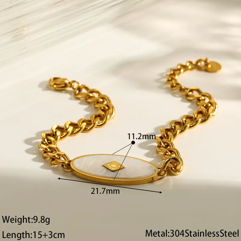 Gold chain bracelet with measurements on a light background