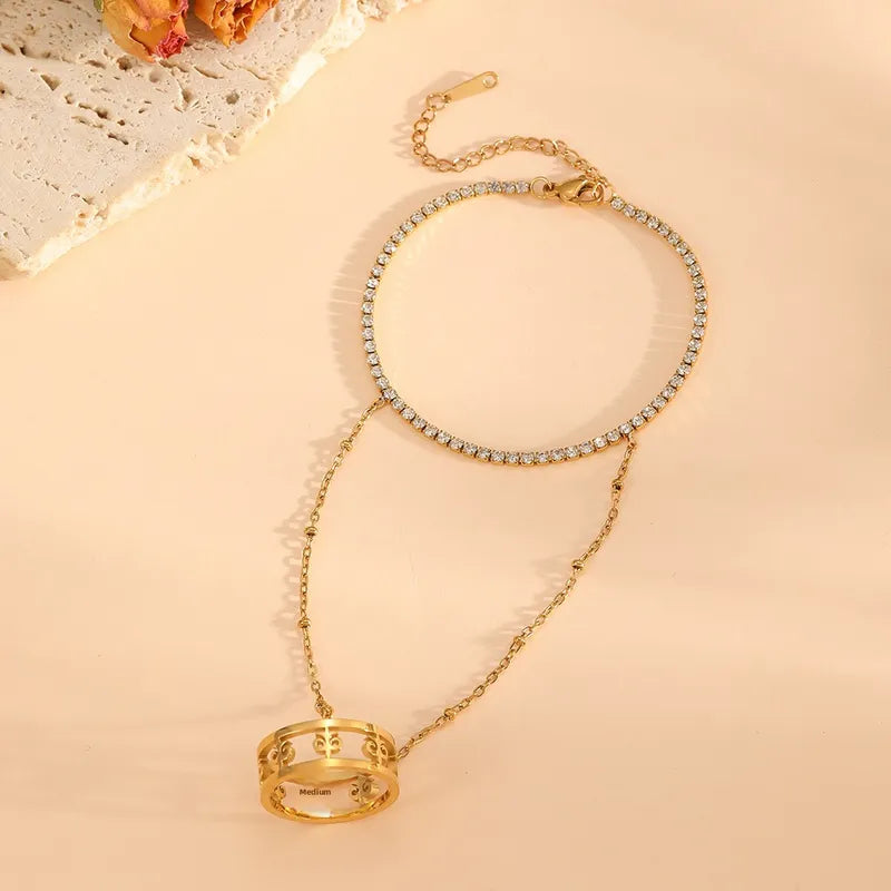 Gold necklace with a ring pendant on a beige background