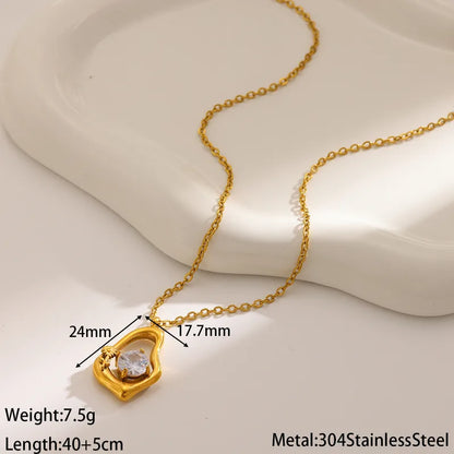 Gold necklace with heart-shaped pendant on a light background