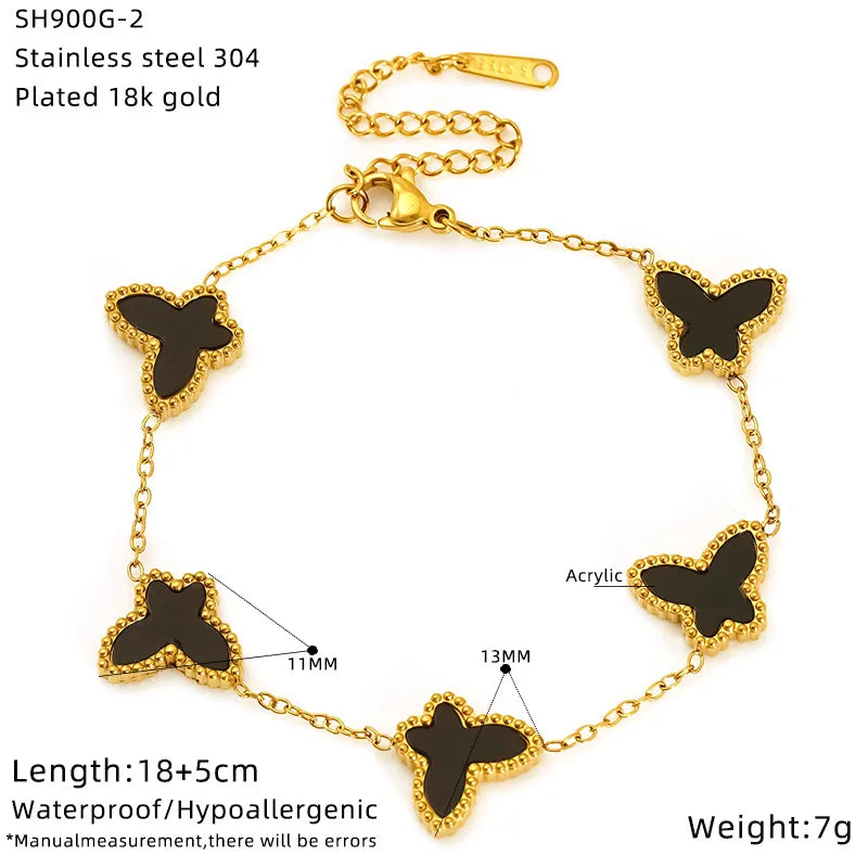 Gold bracelet with black butterfly charms on a white background