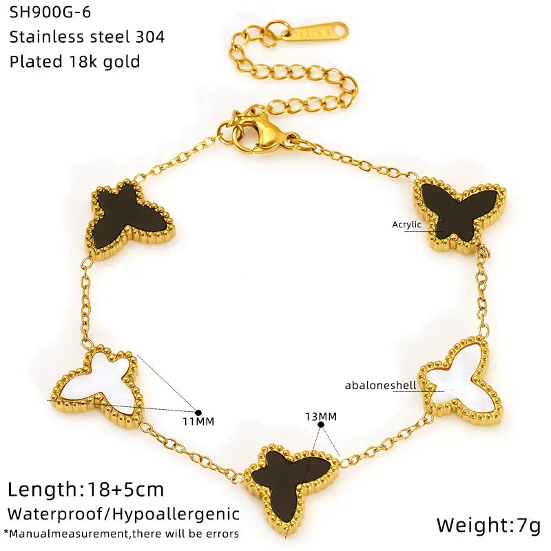 Gold bracelet with butterfly-shaped black stones on a white background