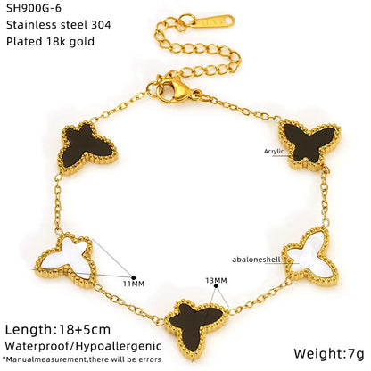 Gold bracelet with butterfly-shaped black stones on a white background