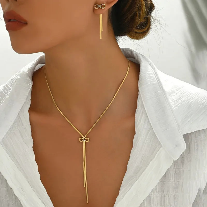 Gold necklace and earrings on a model wearing a white shirt