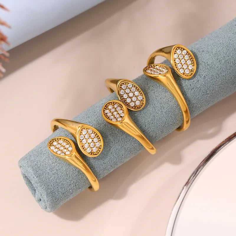 Set of gold bracelets with diamond-like stones on a textured surface