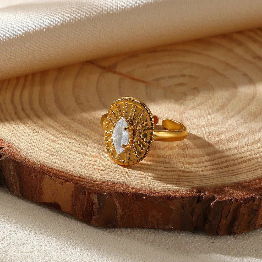 Gold ring with a central gemstone on a wooden surface